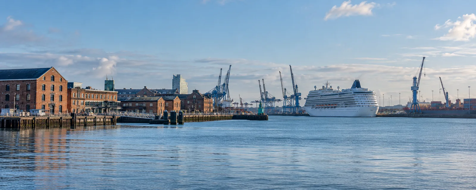 Commercial waterfront, cargo cranes and a cruise liner on Southampton Water